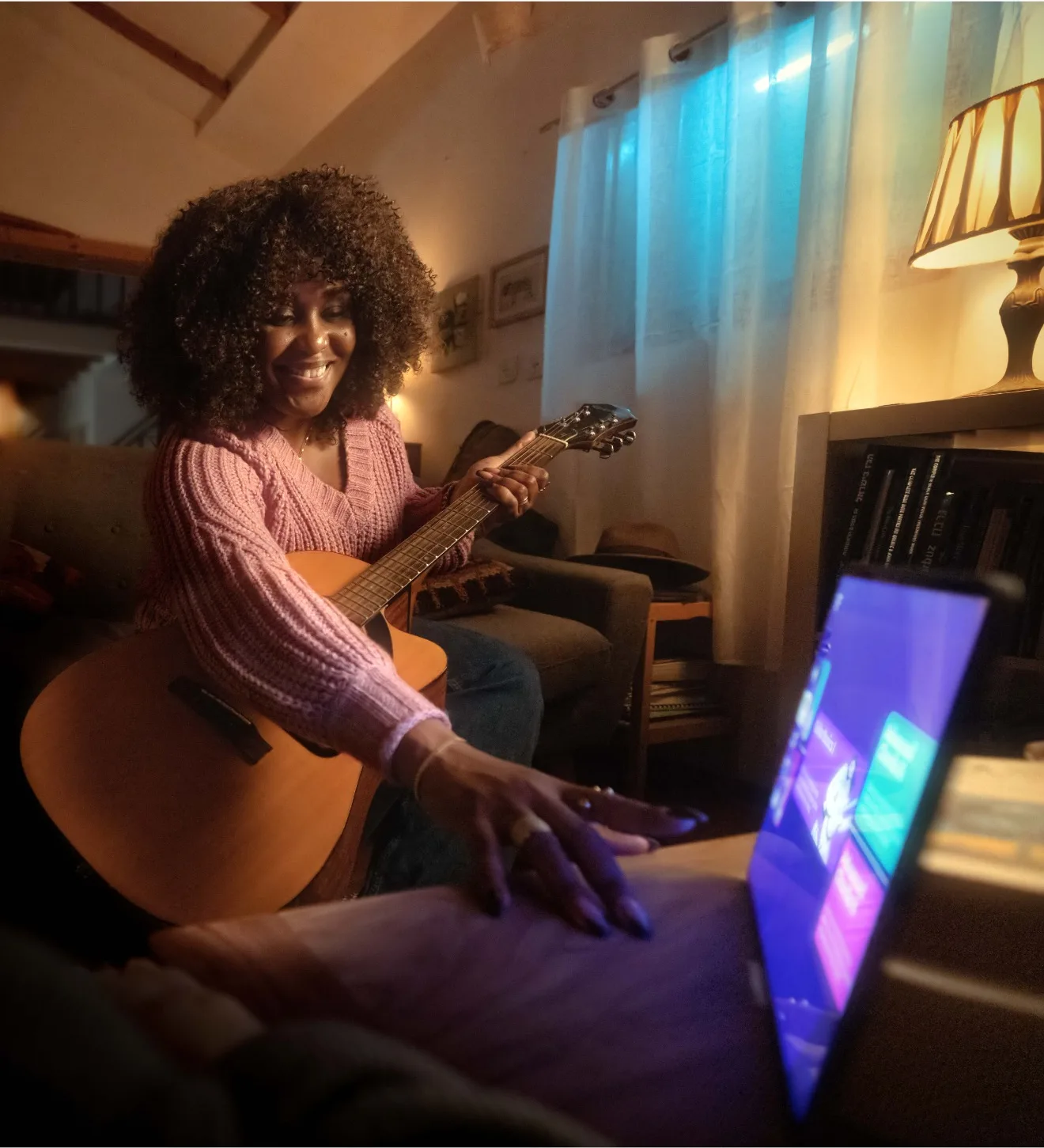 A woman with a guitar reaches for Simply Guitar on a tablet in a warm living room